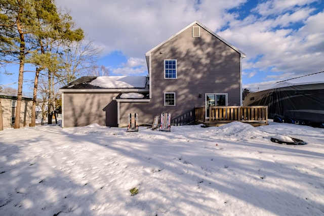 snow covered rear of property featuring a deck