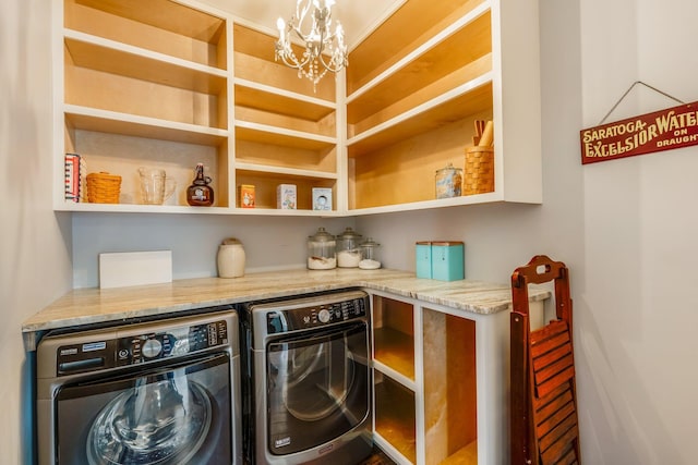 clothes washing area with washer and dryer, laundry area, and an inviting chandelier