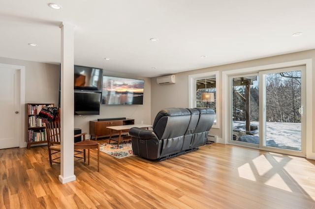 living room with a baseboard heating unit, recessed lighting, light wood-style floors, and a wall mounted AC