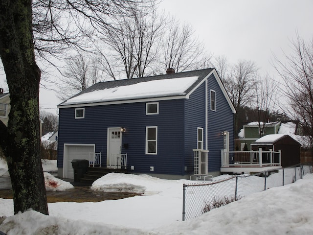 view of front of house with a garage, a chimney, and fence