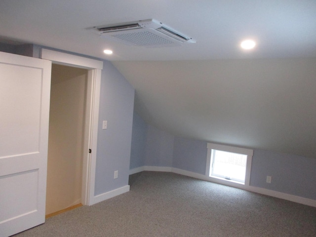 additional living space with baseboards, visible vents, vaulted ceiling, and carpet flooring