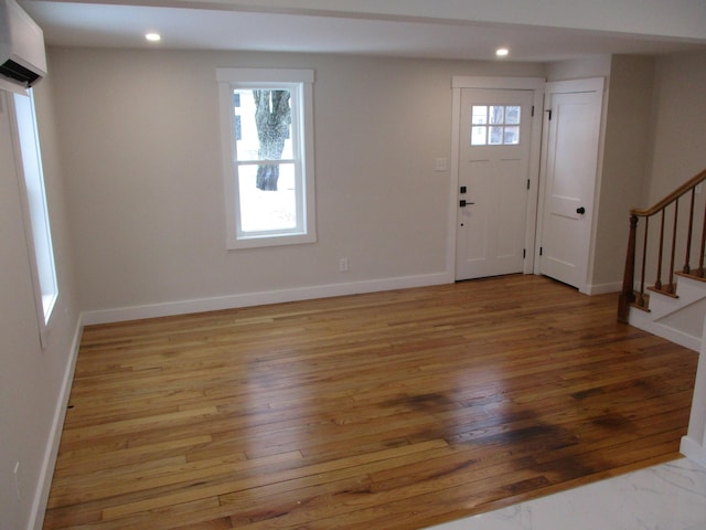 foyer featuring recessed lighting, wood-type flooring, baseboards, and stairs