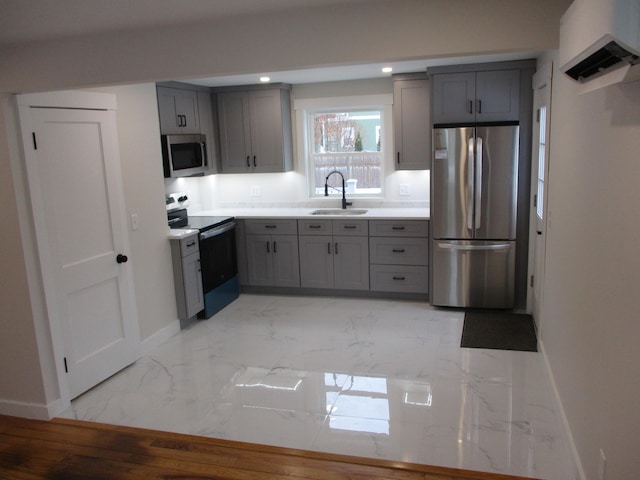 kitchen featuring stainless steel appliances, a sink, baseboards, marble finish floor, and gray cabinets