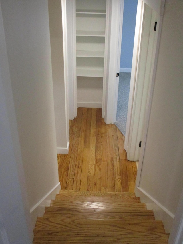 hall featuring stairway, light wood-style flooring, and baseboards