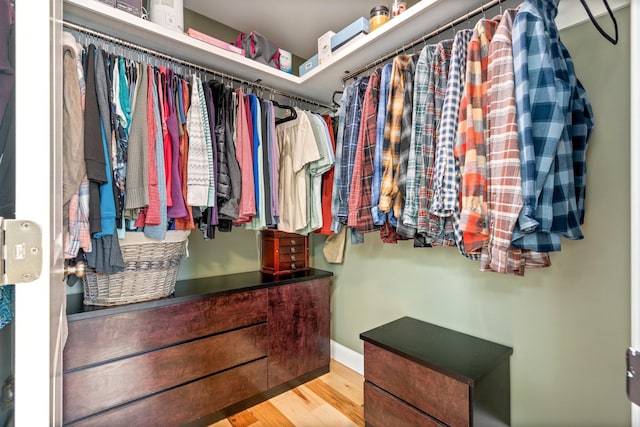 walk in closet with wood finished floors