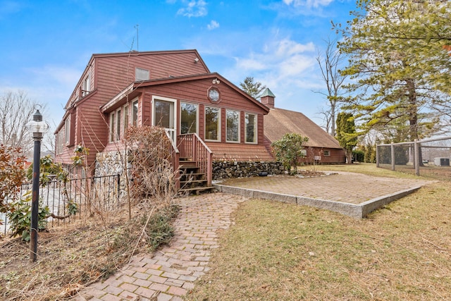 rear view of house with fence and a yard