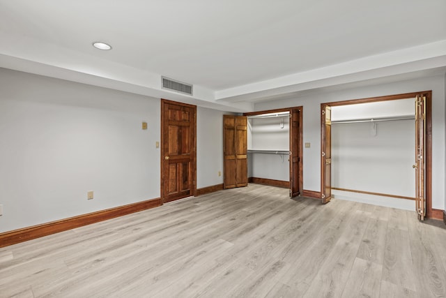 unfurnished bedroom with recessed lighting, light wood finished floors, visible vents, baseboards, and two closets