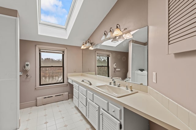 bathroom featuring a baseboard heating unit, vanity, and lofted ceiling with skylight
