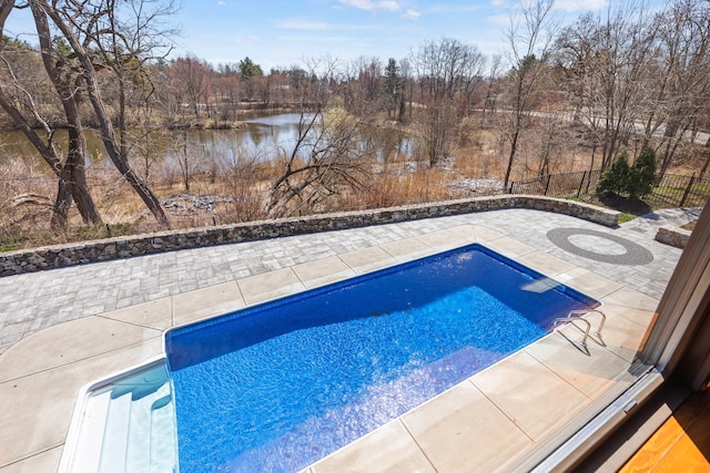 view of swimming pool with a patio area, a fenced in pool, a water view, and fence