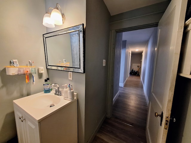 bathroom with vanity, baseboards, and wood finished floors