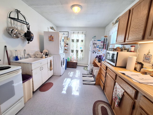 kitchen with a baseboard radiator, light countertops, white range with electric cooktop, and stacked washer and clothes dryer