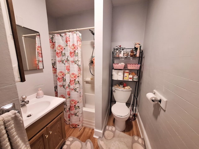 bathroom with shower / bathtub combination with curtain, vanity, toilet, and wood finished floors