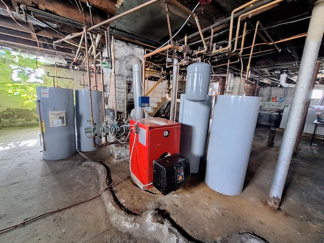 utility room featuring gas water heater, electric water heater, and a heating unit