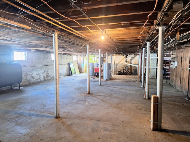 basement with water heater, heating fuel, and electric water heater