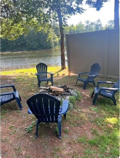 view of yard with a water view and an outdoor fire pit