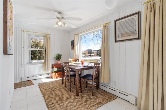 dining area featuring a baseboard heating unit, ceiling fan, and light tile patterned flooring