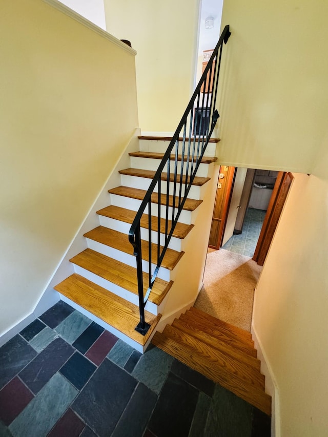 stairs featuring baseboards and stone tile floors