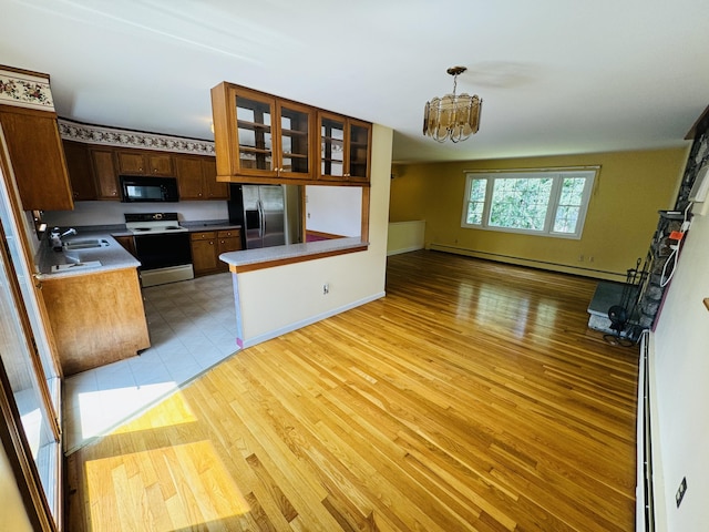 kitchen with range with electric cooktop, stainless steel fridge with ice dispenser, open floor plan, a baseboard heating unit, and black microwave