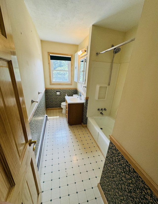 bathroom featuring a textured ceiling, bathtub / shower combination, toilet, vanity, and tile patterned floors