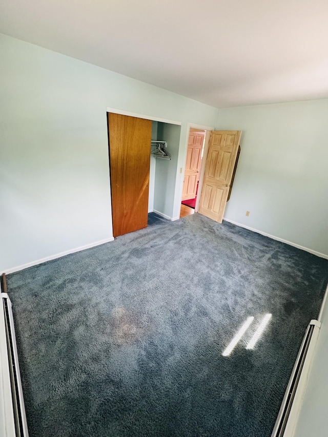 unfurnished bedroom featuring baseboards and dark carpet