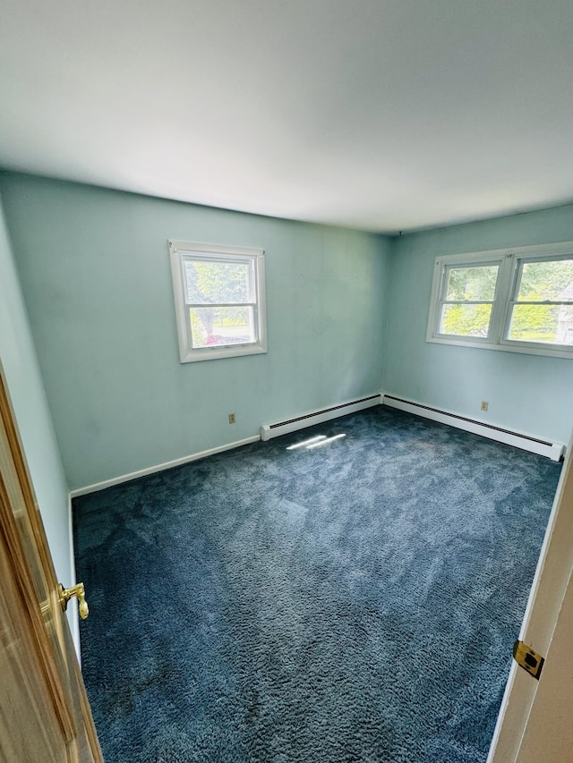 carpeted spare room with plenty of natural light and baseboard heating