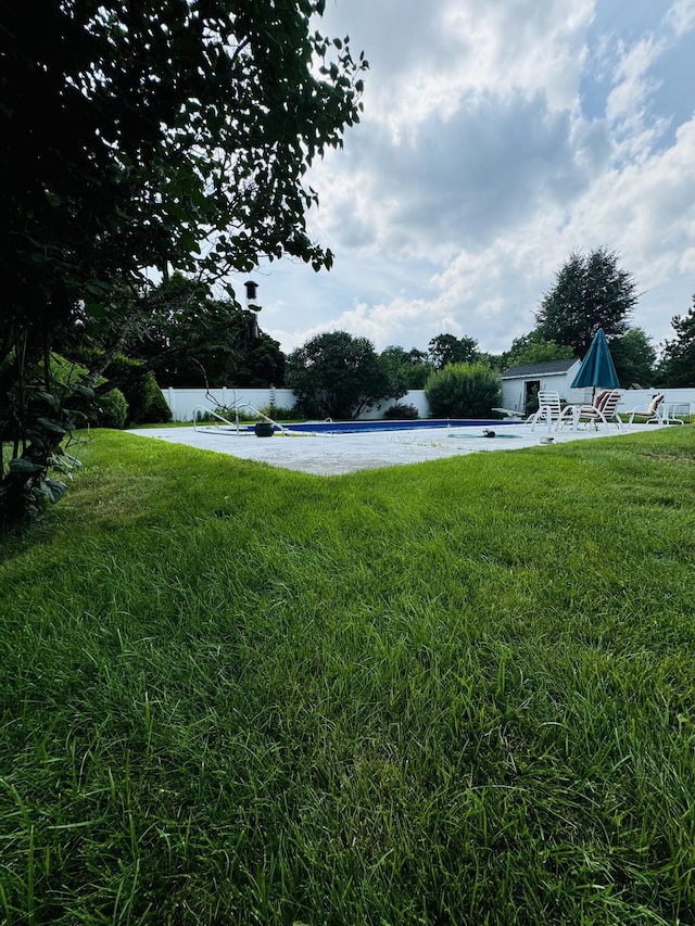 view of yard with a water view and an outdoor pool