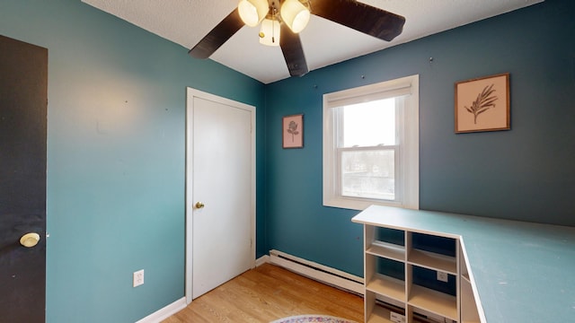 unfurnished bedroom with light wood-style flooring, a baseboard radiator, and ceiling fan