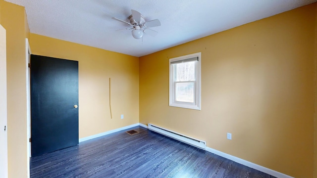 empty room with baseboard heating, ceiling fan, baseboards, and dark wood-style floors