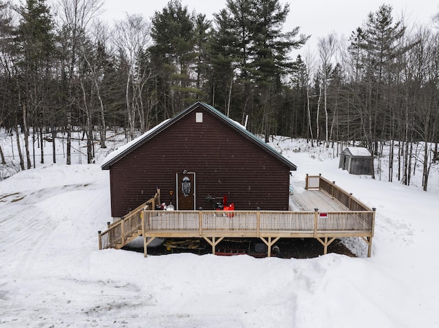 snow covered house featuring a wooden deck