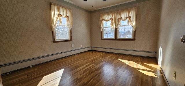 empty room with a baseboard heating unit, hardwood / wood-style floors, and wallpapered walls