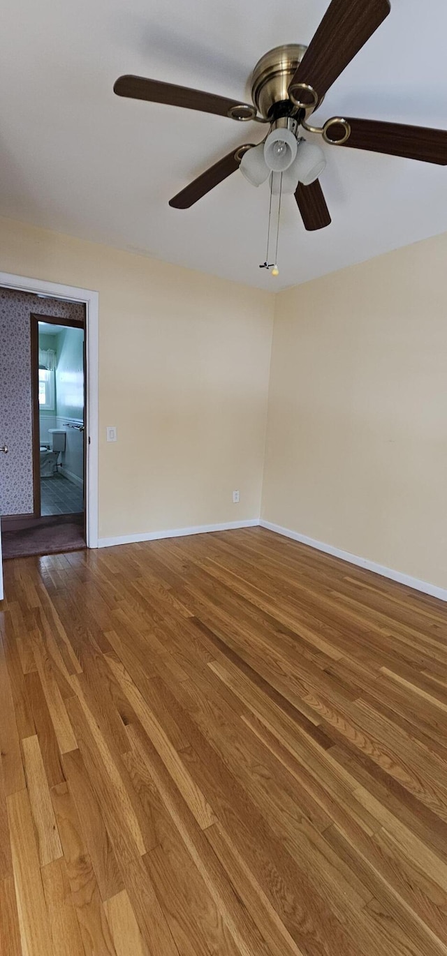 spare room with light wood-style floors, ceiling fan, baseboards, and wallpapered walls