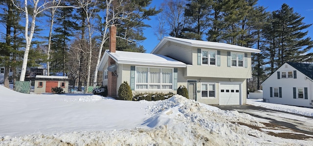 tri-level home featuring a garage and a chimney