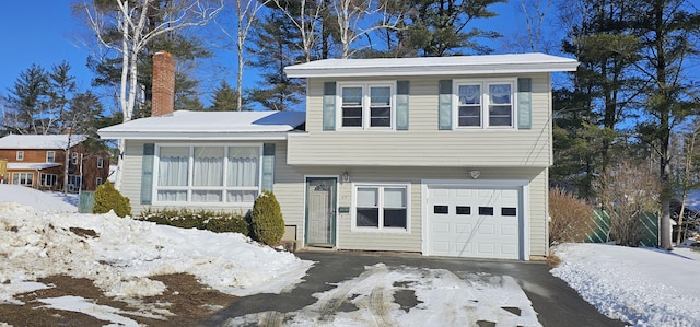 split level home featuring a chimney and an attached garage