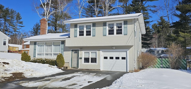 split level home featuring a garage and a chimney