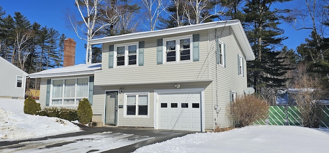 view of front facade featuring an attached garage and a chimney