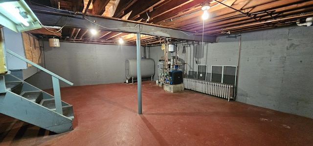 unfinished below grade area featuring radiator heating unit, a heating unit, and heating fuel