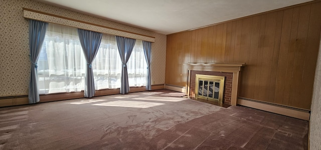 unfurnished living room with carpet floors, a brick fireplace, a baseboard radiator, and wallpapered walls