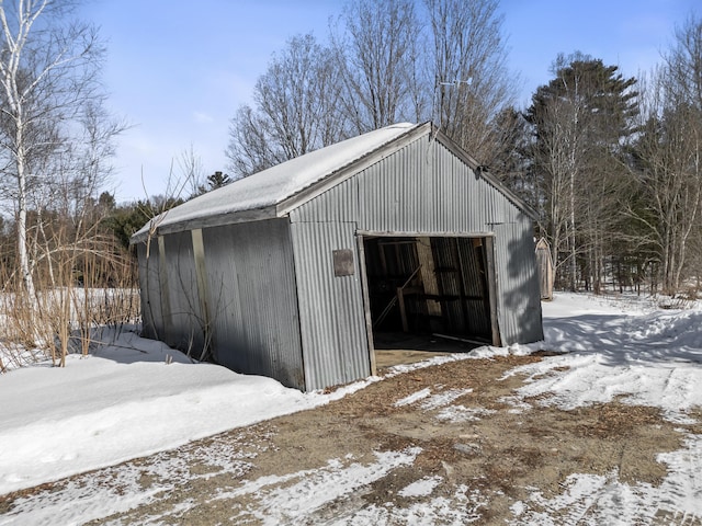 snow covered garage featuring a detached garage