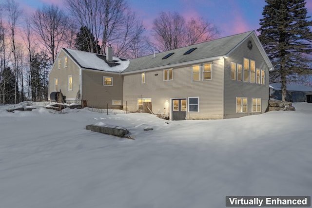 snow covered property with a chimney