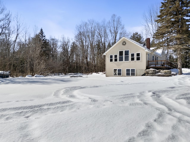 snow covered property featuring a chimney