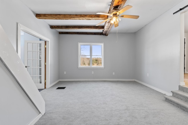 carpeted empty room with beam ceiling, visible vents, baseboards, and a ceiling fan