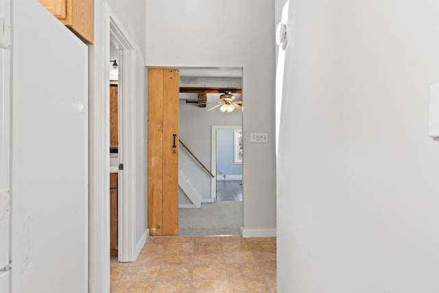 hallway with light tile patterned flooring, stairs, and baseboards