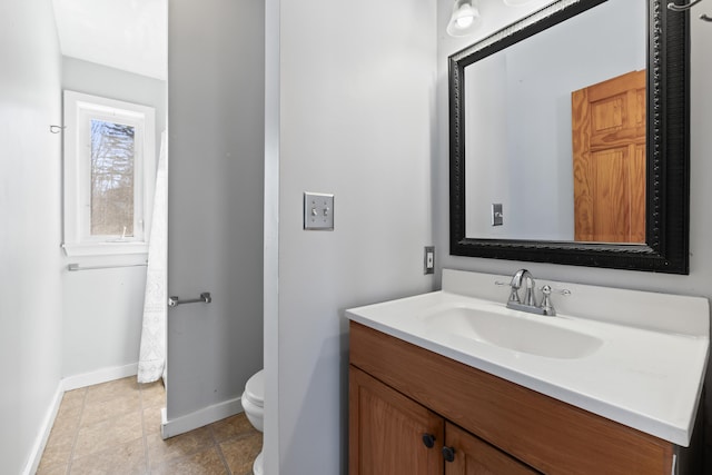 bathroom featuring tile patterned flooring, toilet, vanity, and baseboards