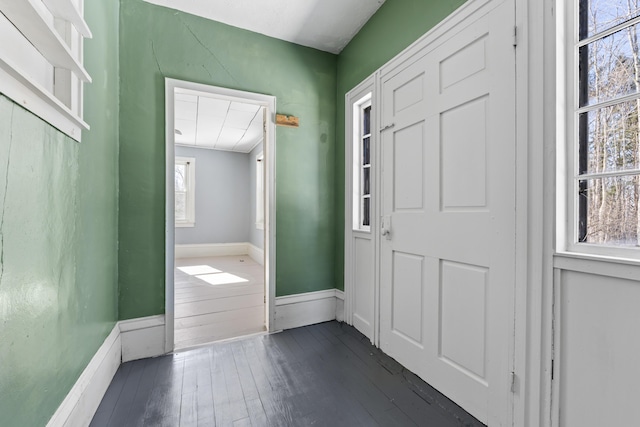 doorway featuring dark wood-type flooring and baseboards