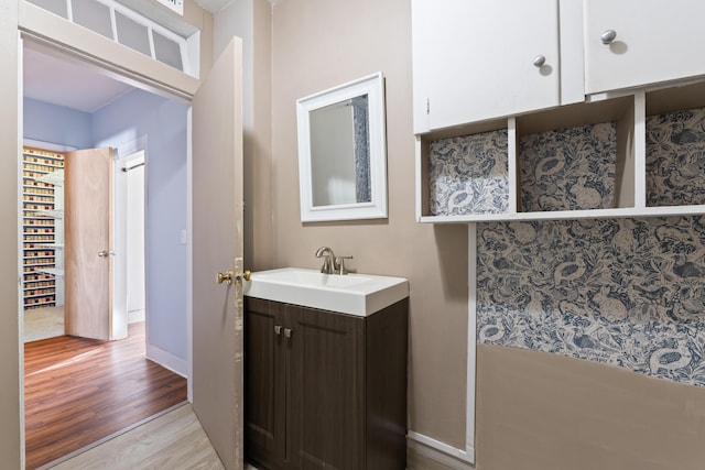 bathroom featuring vanity, wood finished floors, and baseboards