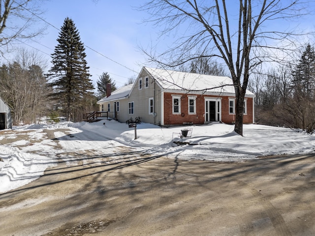 view of front of home with brick siding and a chimney