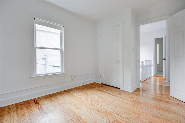 spare room featuring light wood-style flooring and baseboards