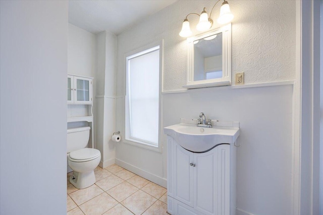 half bathroom featuring vanity, tile patterned flooring, and toilet