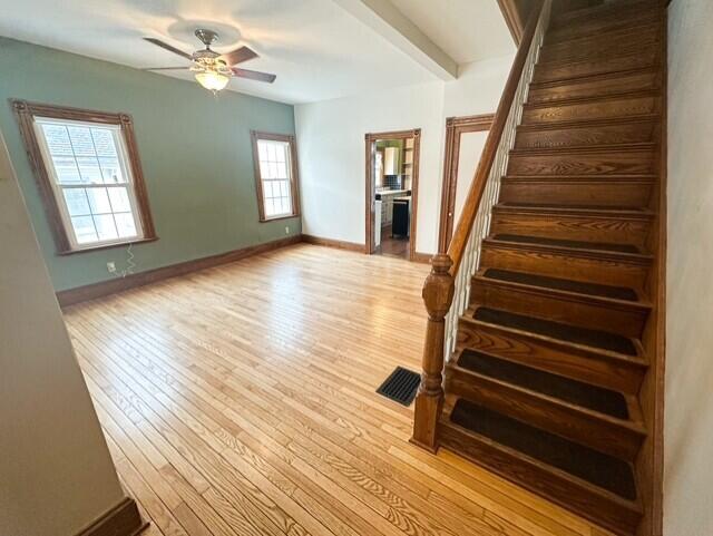 interior space featuring wood finished floors, a ceiling fan, and baseboards