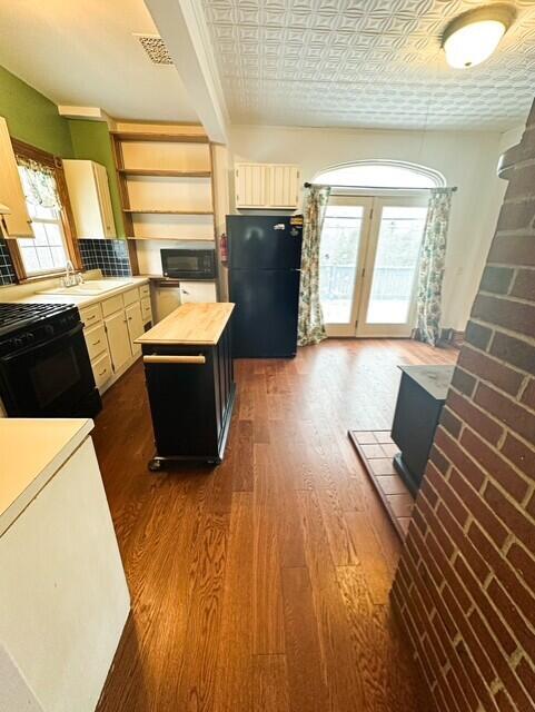 kitchen featuring an ornate ceiling, dark wood finished floors, open shelves, wooden counters, and black appliances